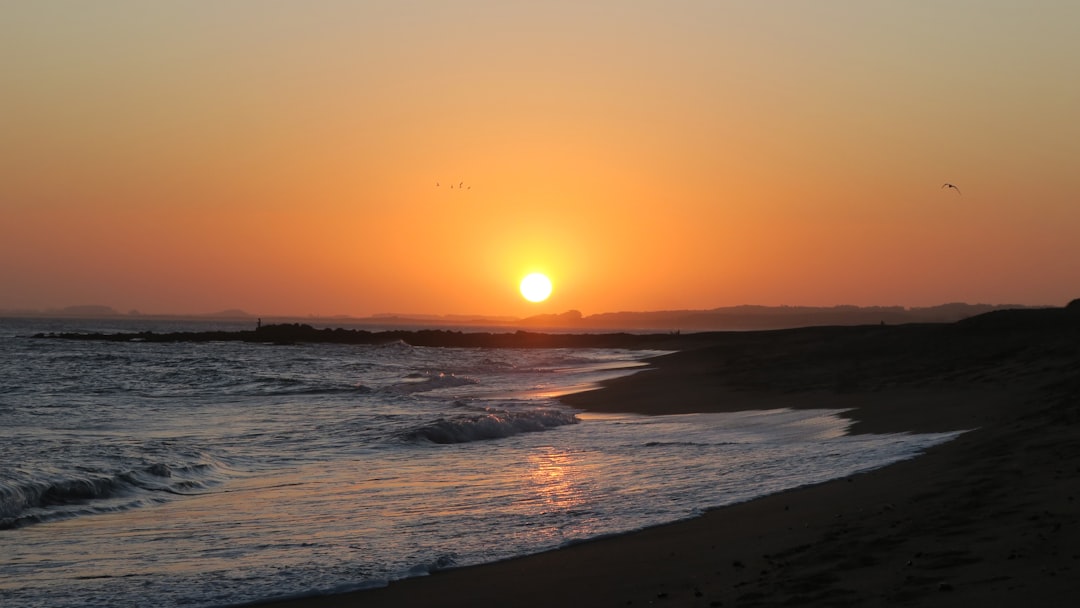 sea waves crashing on shore during sunset