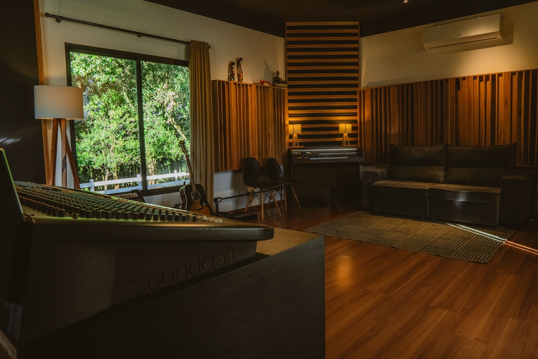 A modern recording studio with soundproofing and large window.