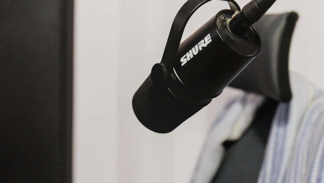 A black shure microphone hangs from a stand.