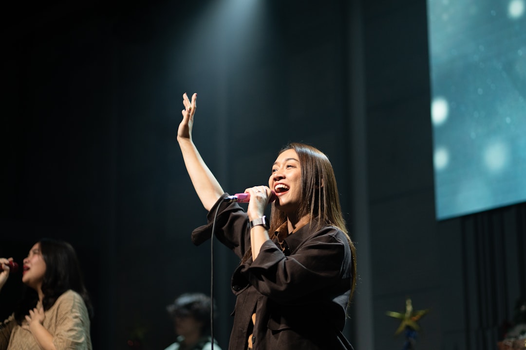Woman singing passionately into a microphone on stage.