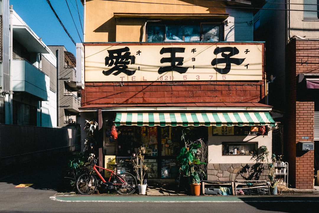 A small storefront with japanese characters and a bicycle.