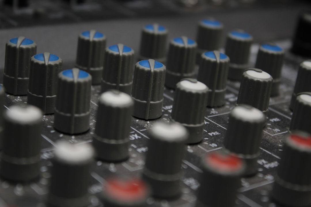 a close up of a sound board with many knobs