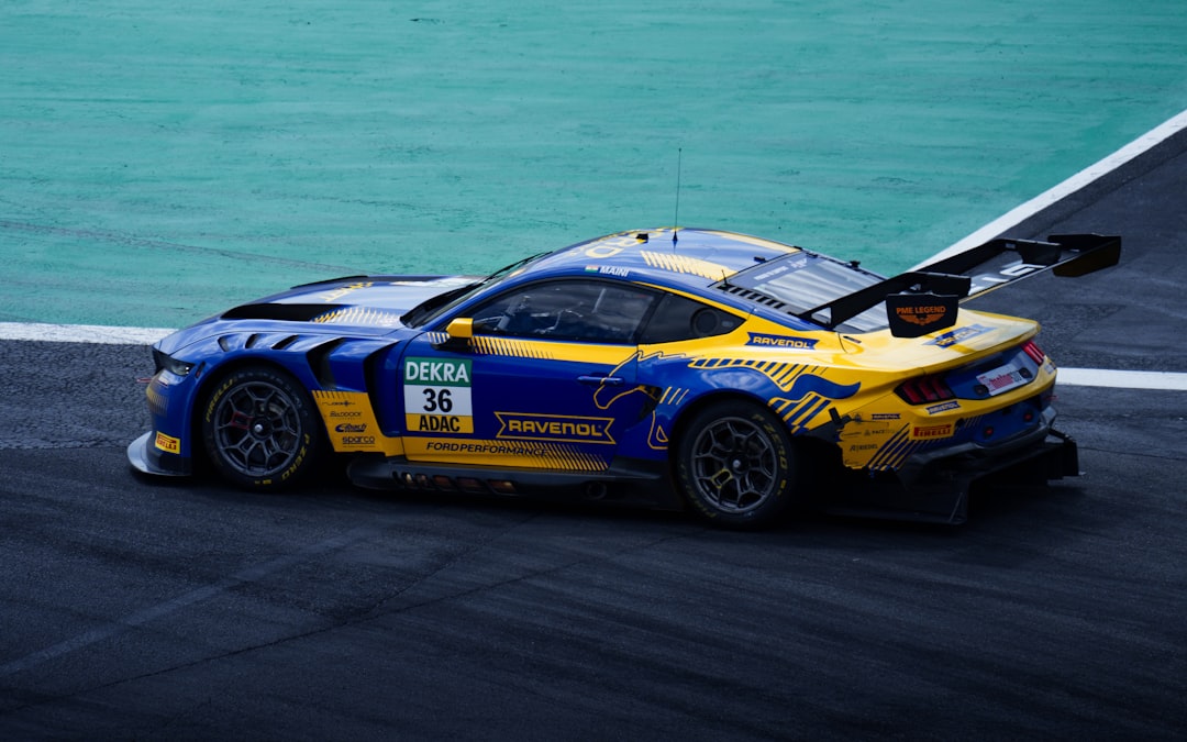 A ford mustang race car speeds on a track.