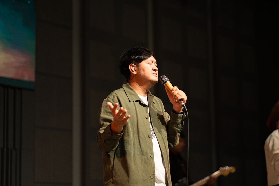 A man singing into a microphone on stage.